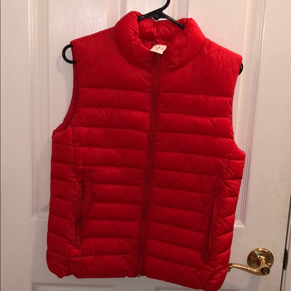 Red puffer vest with tags still on it